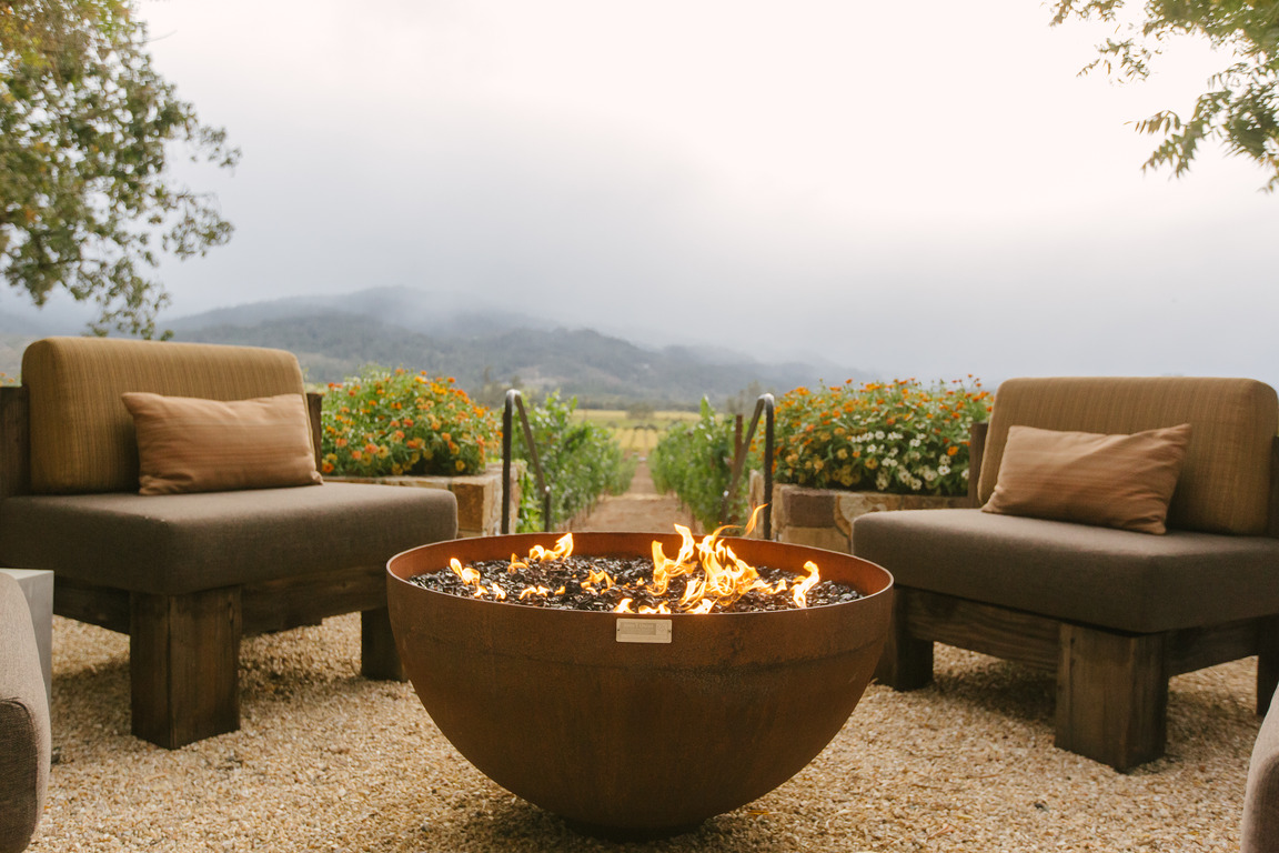 Davis Estate fireplace with couch and a mountain background