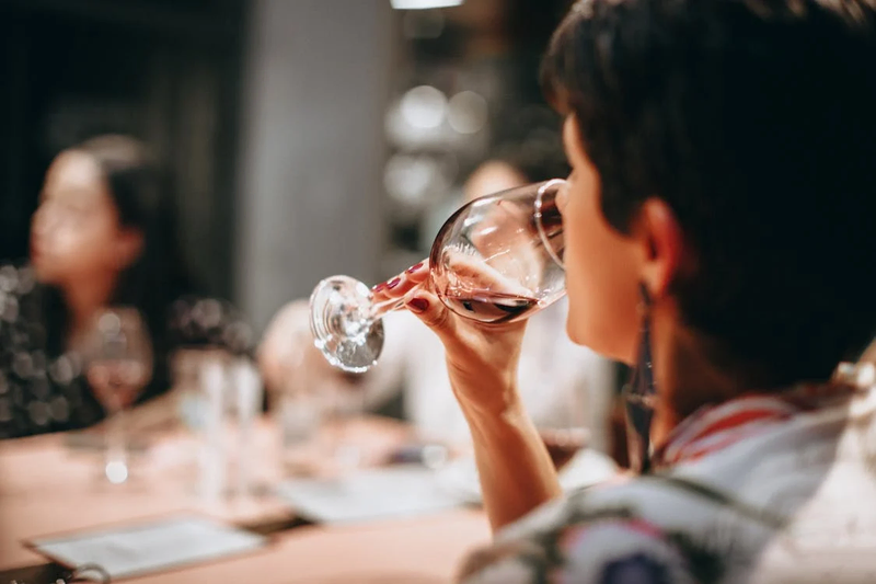 a woman drinking a red wine