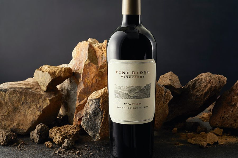 Pine Ridge Vineyards Cabernet Sauvignon bottle set against rocks.