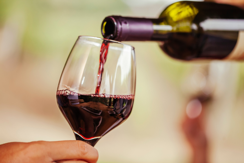 Close-up of red wine being poured into a glass.
