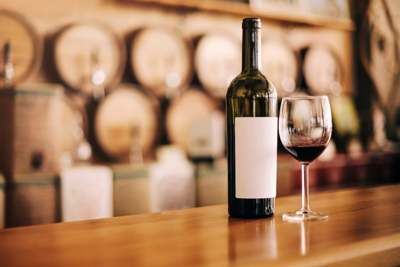 A bottle and glass of red wine on a wooden counter at Davis Estates.